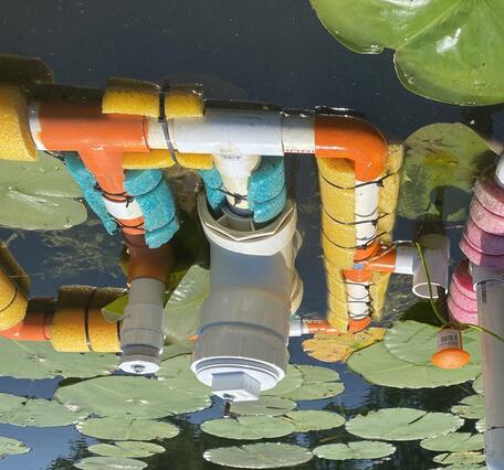 Two water quality floats in a pool with lily pads