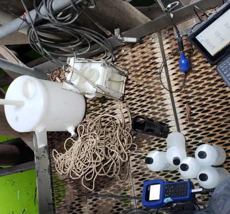 various equipment laid out on an aluminum grate platform. Green water shines below.
