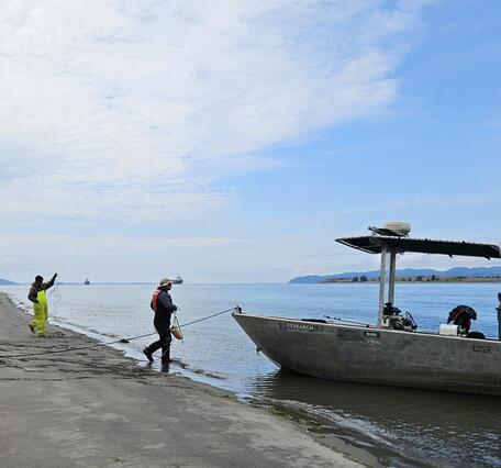 USGS researchers walking to a boat on the Columbia River, OR