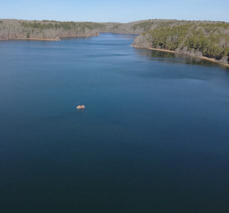 aerial view of pond with small boat on it