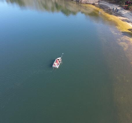 aerial view of pond with small boat on it