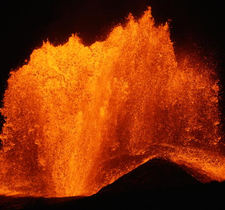 Color photograph of lava fountain at night