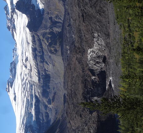 A stream flows from a rock covered glacier