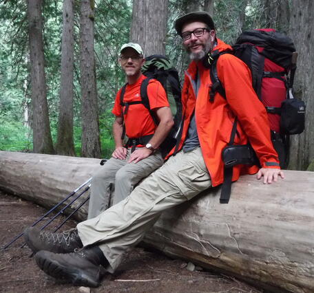 Scientists Carl and Jeff sitting on a fallen tree in Skagit, WA