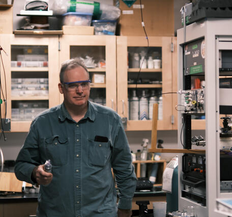 Person holding object in hand walking through a laboratory