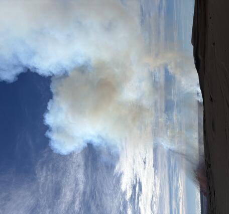 color photo of lava fountain just barely peeking over the crater rim. 