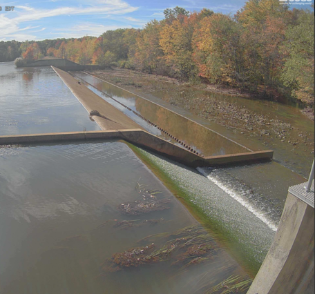 Looking across a dam with water spilling over the closer portion