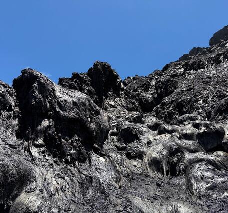 Color photograph of black cooling lava from the August 6th eruption. 