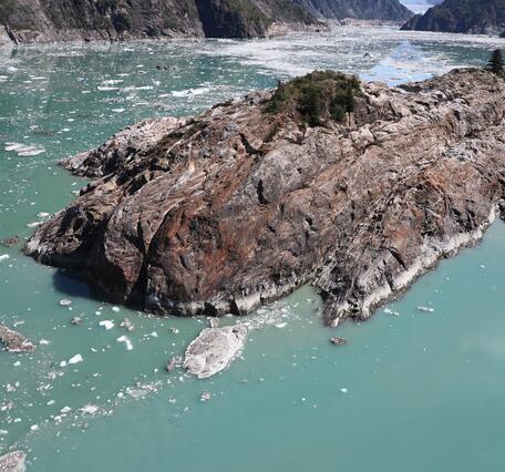 Photo of island in water surrounded by mountains
