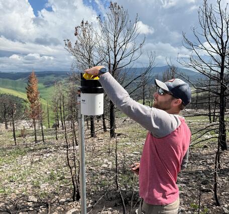 person using a level to measure a rain gage