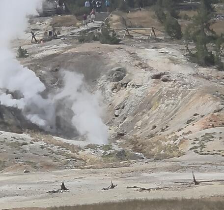 Barren hillside with steaming that marks the locations of two geysers