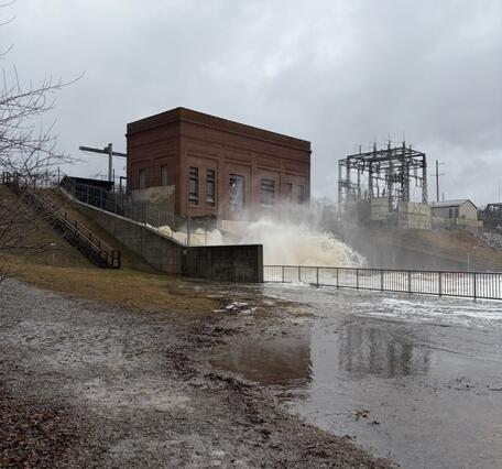 Floodwaters at high flow below historic brick dam