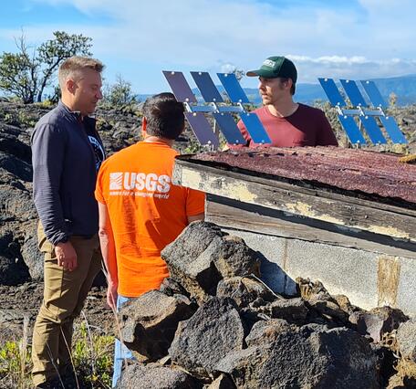 Color photograph of scientists installing experiment in downwind of a volcano