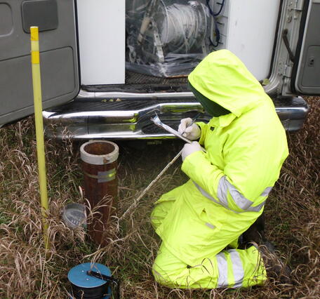 Image of man in hiviz gear taking measurements