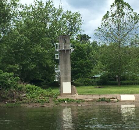 Looking at the concrete tower of the gage from across the river