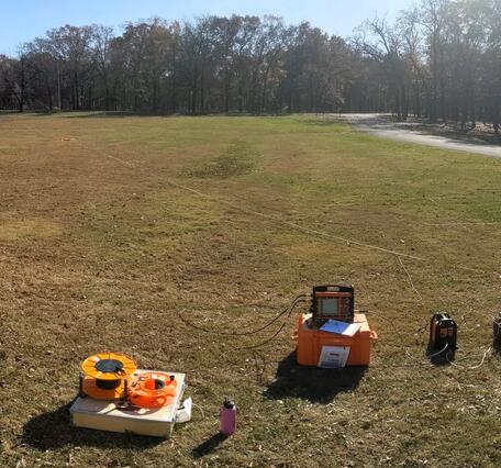 Geophysical survey equipment in a grassy field on a sunny autumn day