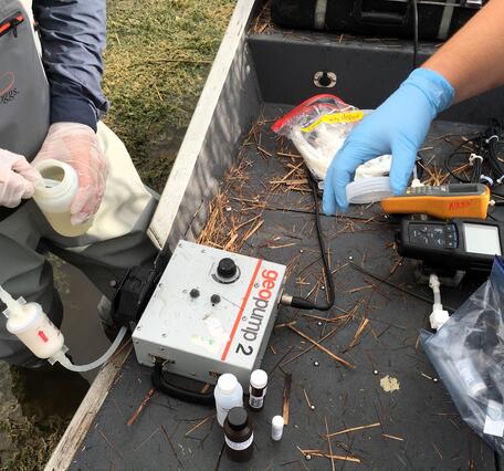 Two scientists filtering water in the field
