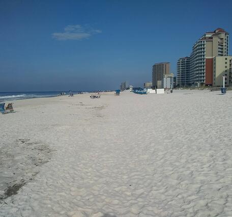 Hotels line an empty white sandy beach in Gulf Shores, Alabama