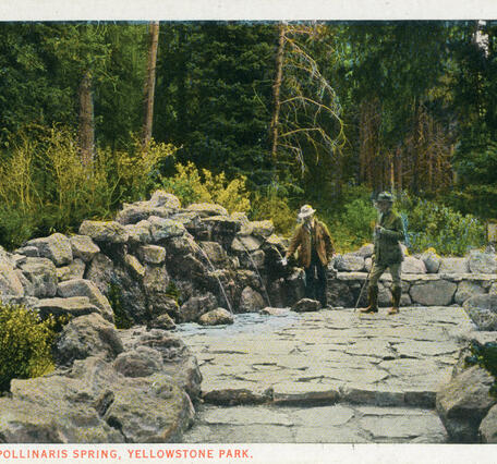 Colored 1920s postcard with two people on a stone platform hosting a cold water spring within a forested area