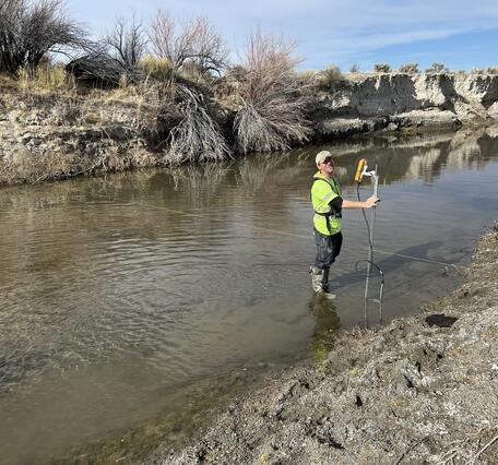 East Walker River flowing past bare trees under cloudy sky  with new streamflow monitoring equipment in foreground.