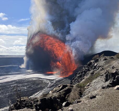 Color photograph of lava fountaining within volcanic crater