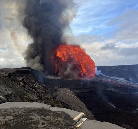 Color photograph of lava fountaining and road