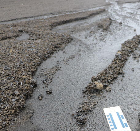 Color photograph of tephra eroded by water and driving on a road