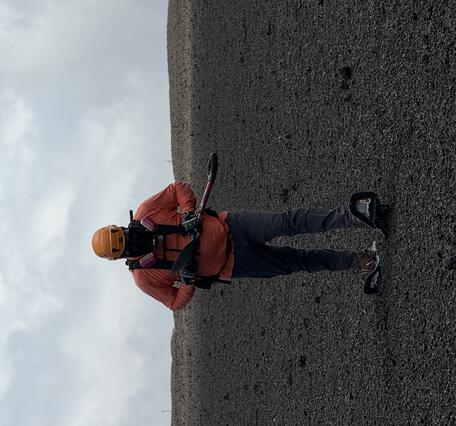 Color photograph of scientist walking on new volcanic deposit