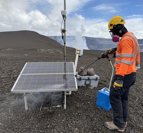 Scientist uses power washer to spray off solar panels