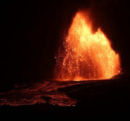 Color photograph of lava fountain at night