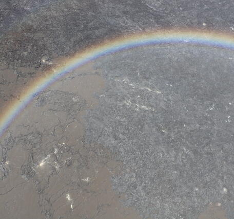 Color photograph of lava flows framed by rainbow