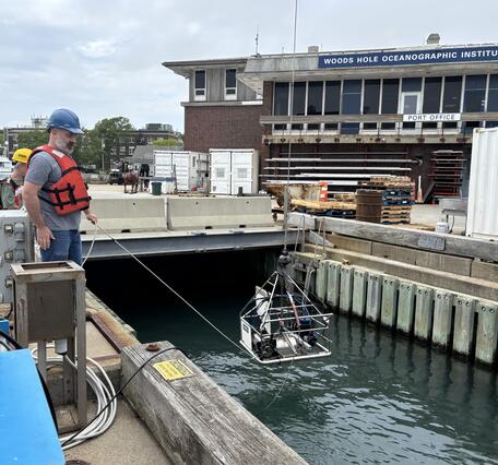 equipment being lowered into the water by people on a dock