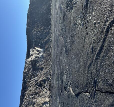 Color photograph of crater floor and steaming crater wall