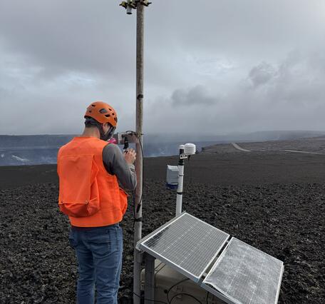 Color photograph of scientist checking monitoring equipment