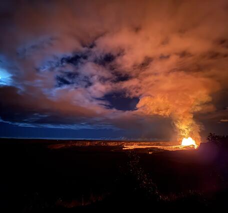 Color photograph of volcanic eruption and full moon