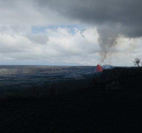 Color photograph of lava fountain within volcanic crater