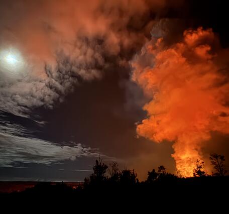 Color photograph of volcanic plume and full moon