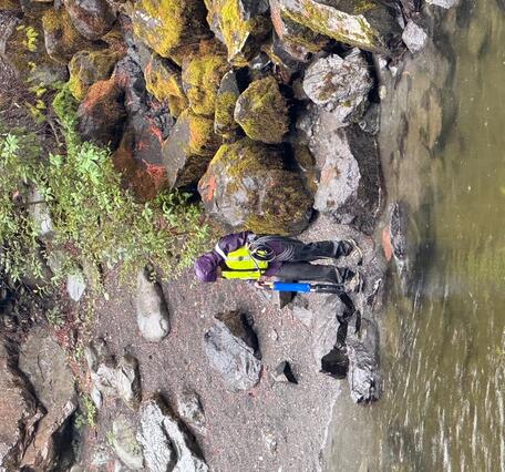 Scientist carries measuring device near river