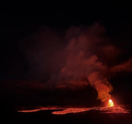 Color photograph of lava fountain and flows at night