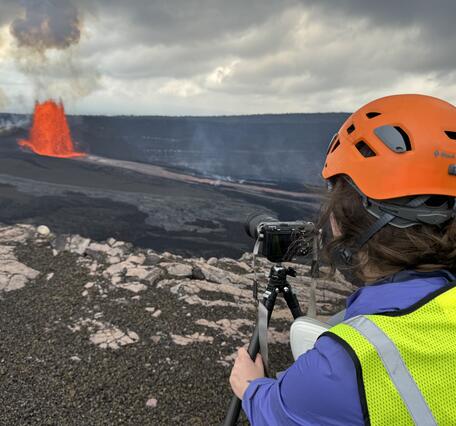 Color photograph of scientist monitoring volcanic eruption