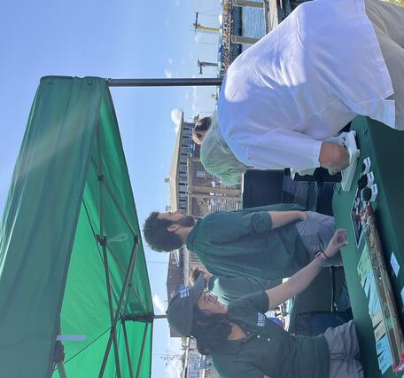 person at USGS booth talking to attendee who is looking at items on the table