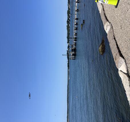 drone flying in the air over the ocean near the shore