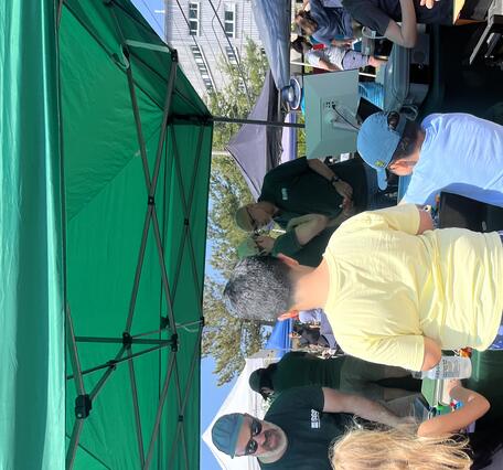 three kids visiting the USGS booth under a tent outside