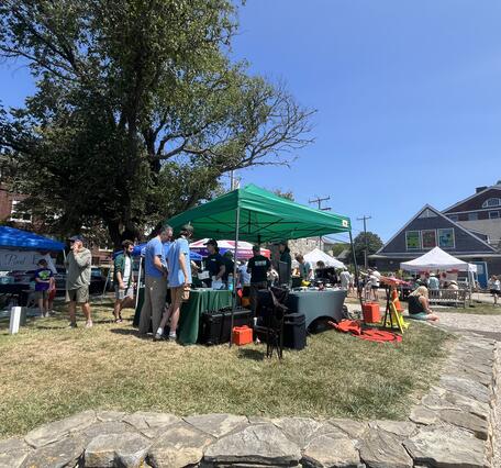USGS tent and four tables with people visiting the booths to talk to the scientists