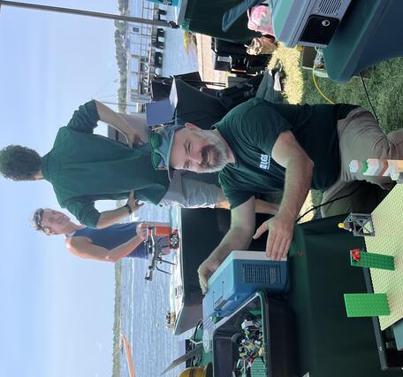 people in USGS shirt smiling at child using the earthquake shake table