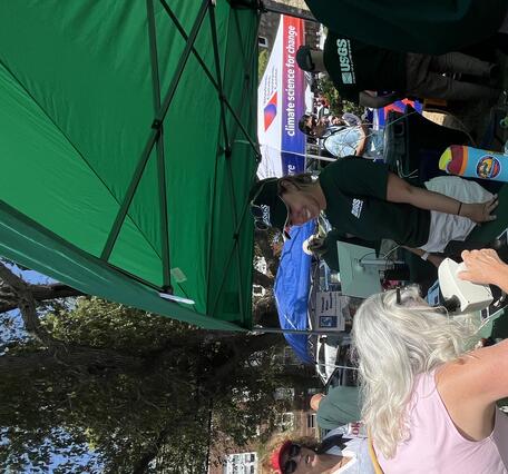 woman looking through microscope at outdoor event