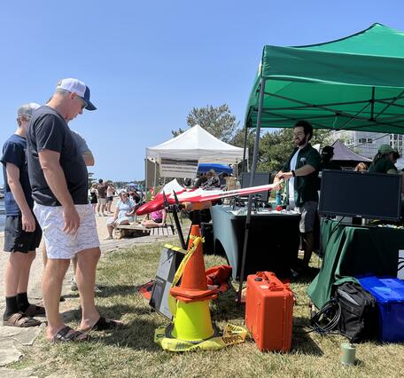 people looking at drone at USGS tent outside