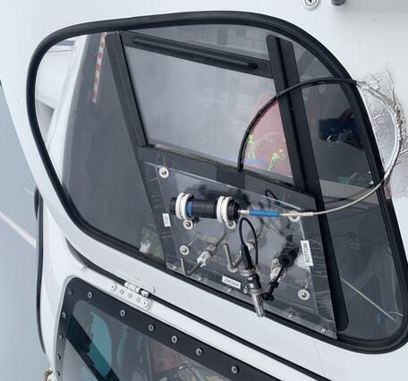 Color photo of the sampling equipment connected to the window of the helicopter. 