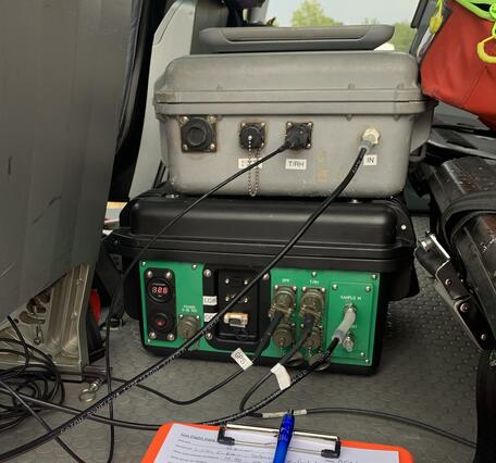Color photo of gas monitoring tools inside the helicopter with a notebook. 