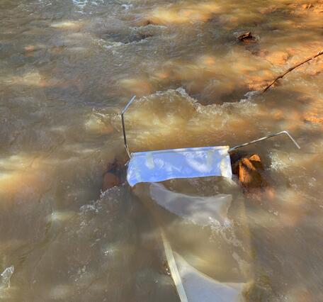 A white net in an orange creek.